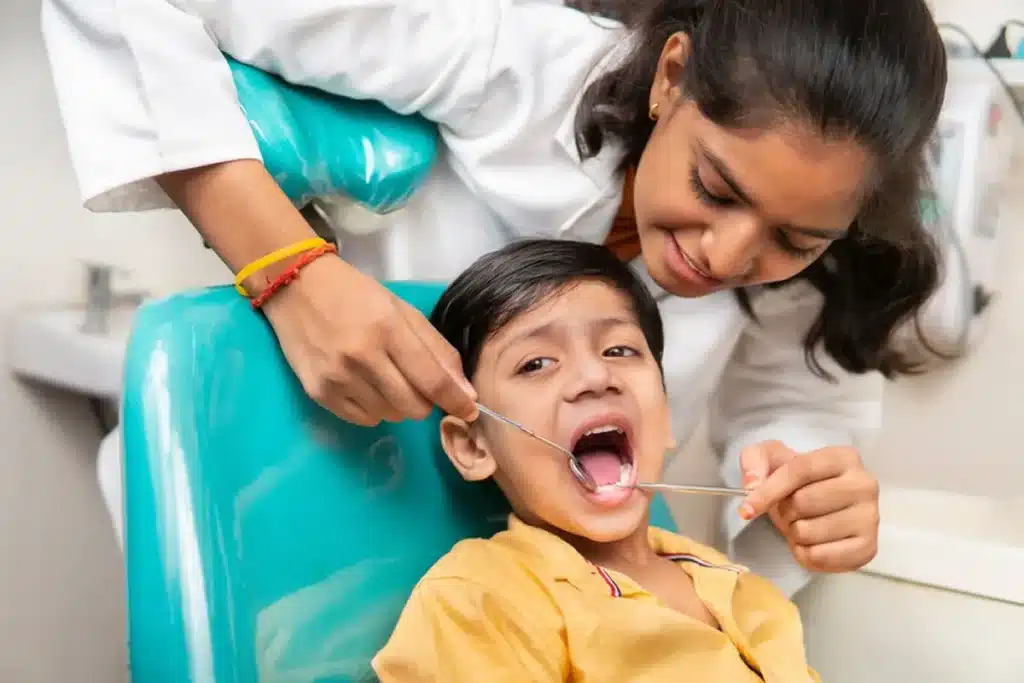 Pediatric dentist examining a child’s teeth during first dental visit in Jammu