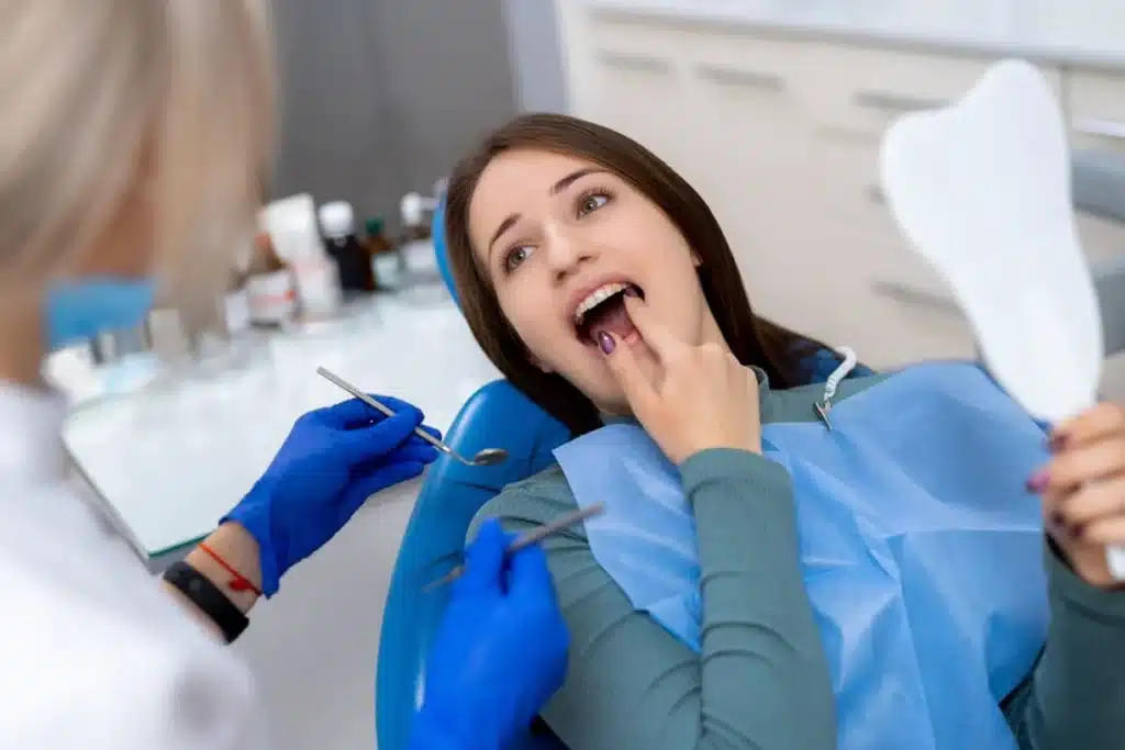 Woman patient showing her teeth to dentist during dental checkup